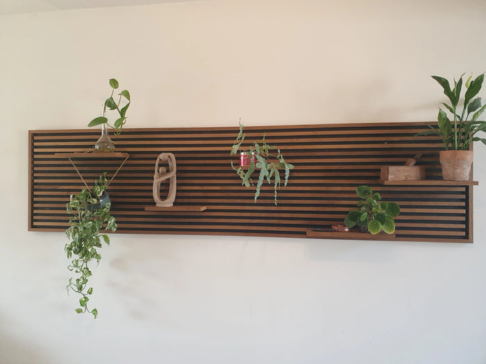 Wandpaneel van Fraké met vijf zwevende plankjes en planten